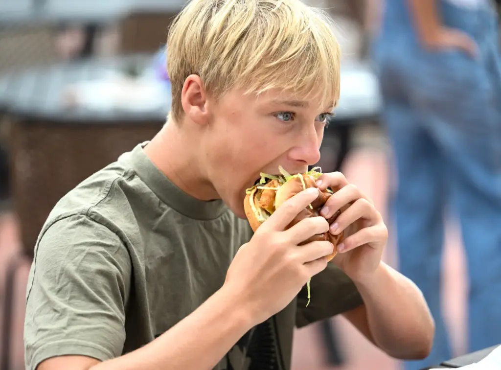 Van Thomason eats the chicken sandwich from Cosmos during opening...