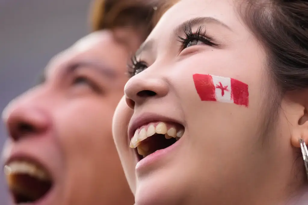 A fan of Canada waits for the start of a...