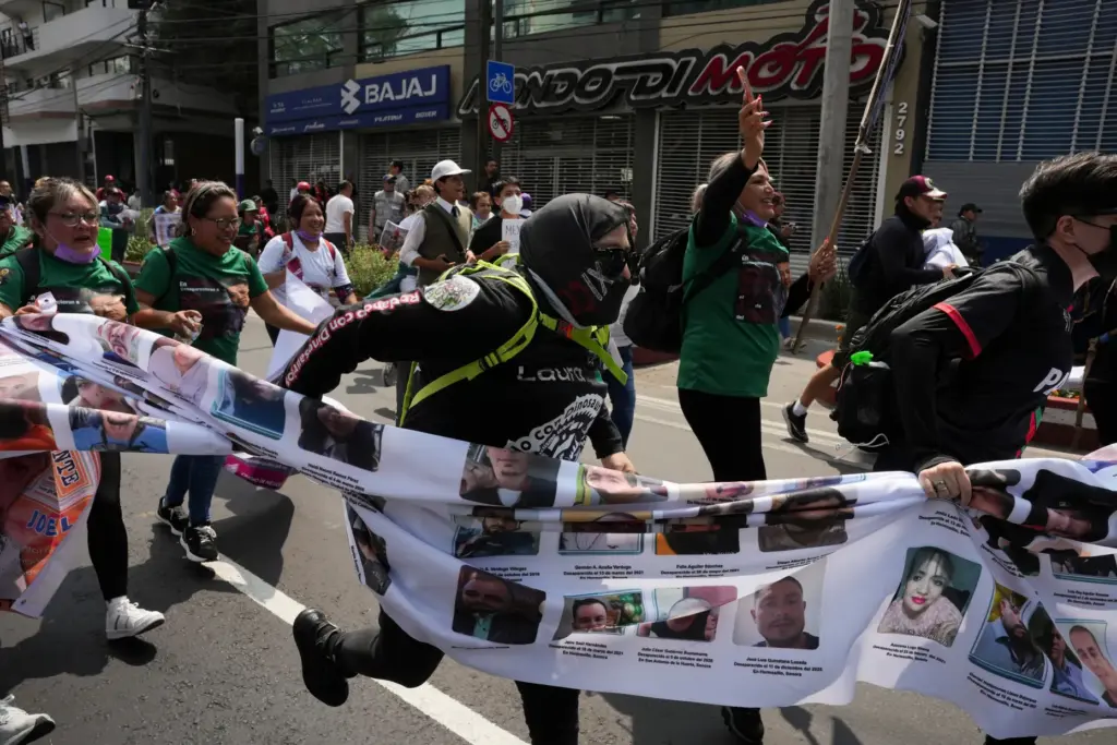 Relatives of Mexico’s disappeared and protesters march before the opening...
