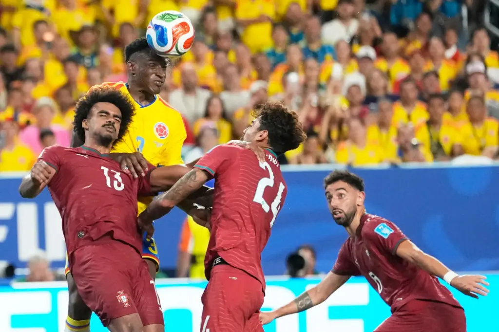 Colombia’s Jhon Lucumi (3) leaps above Portugal’s Renato Veiga (13)...