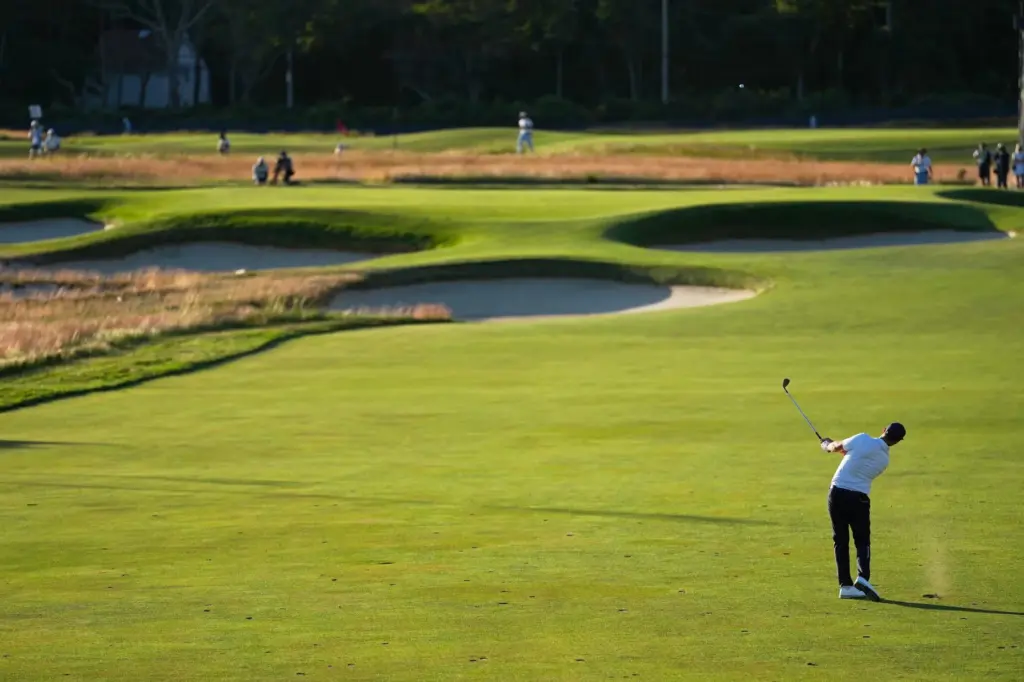 Wyndham Clark hits from the fairway on the 15th hole...