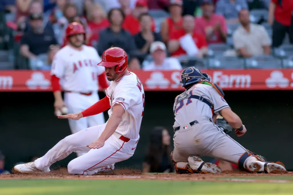 The Angels’ Trey Mancini slides home to score behind Houston...