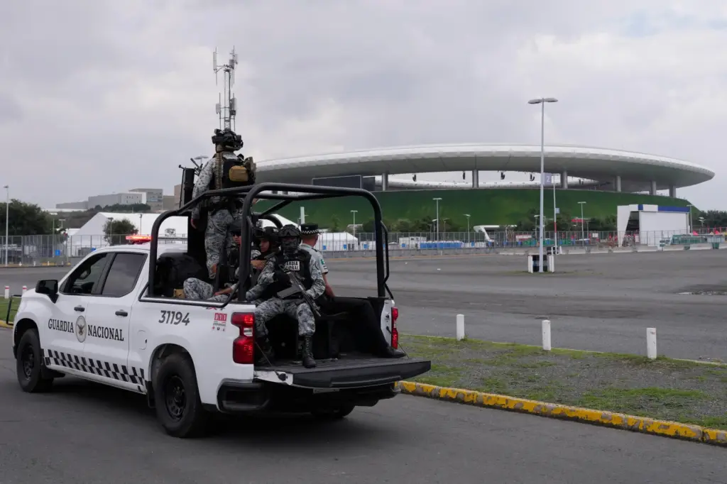 National Guard officers ride past the stadium that will host FIFA World Cup matches in Guadalajara.