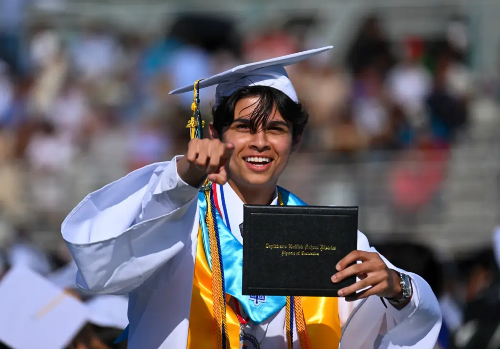Graduate Tej Patel gestures to the crowd after getting his...