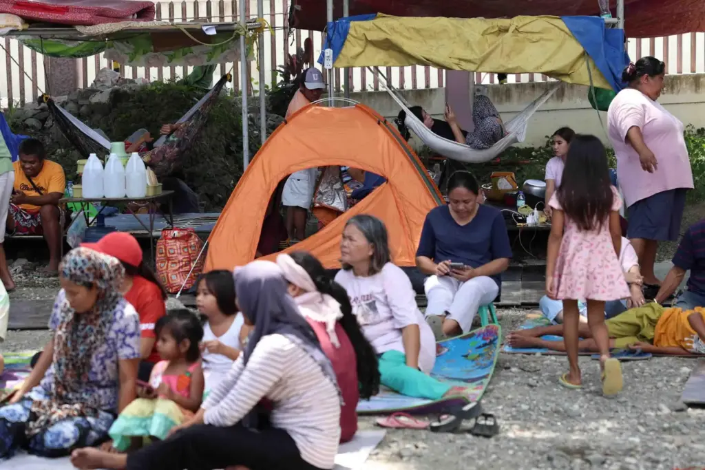 Residents take shelter in a field at a municipal hall...