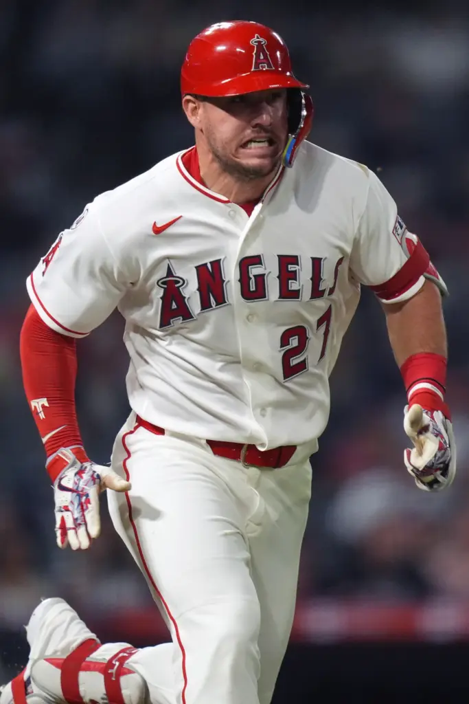 Angels star Mike Trout runs to first base while reaching...