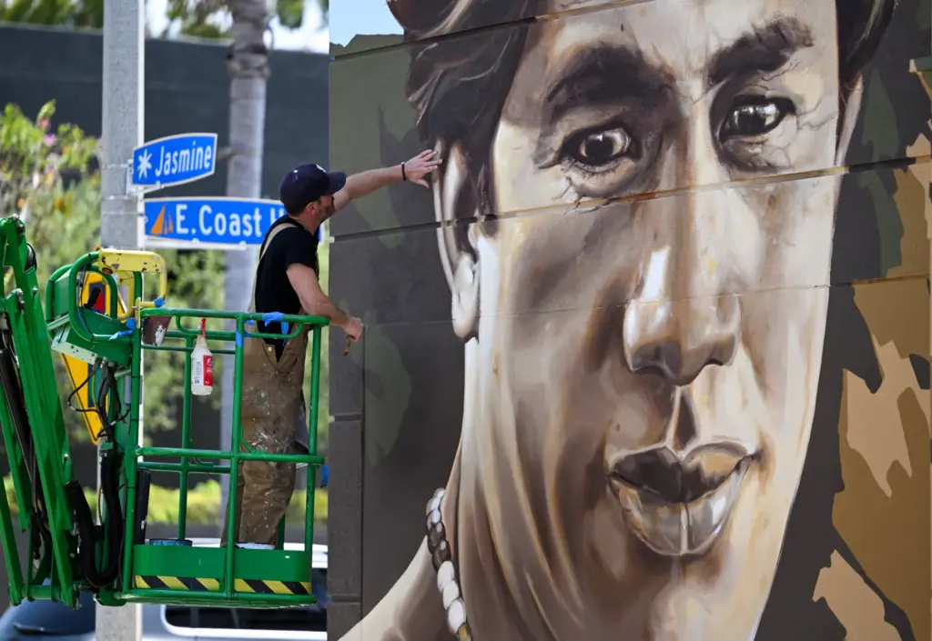 Artist Jack Stricker puts the finishing touches on a mural...