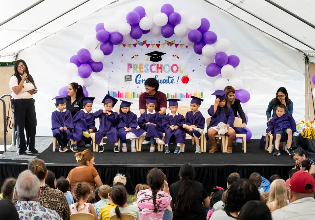 Students listen to speakers during their preschool promotion ceremony at...