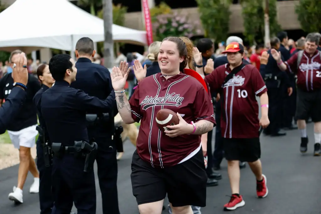 Athletes are greeted by scores of law officers as they...