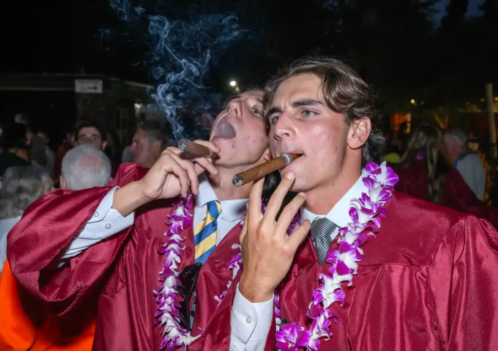 Friends Trent Beason, left, and Otis Boultinghouse smoke celebratory cigars...