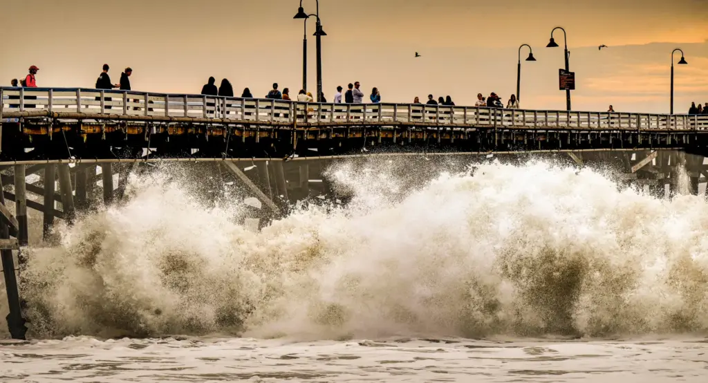 Visitors to the San Clemente Pier watch as the pounding...