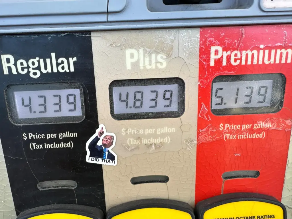 A sticker with the image of President Donald Trump points to gas prices.