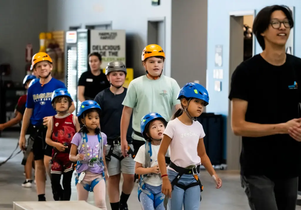 Campers head to the climbing walls during Rock Climbing Camp...