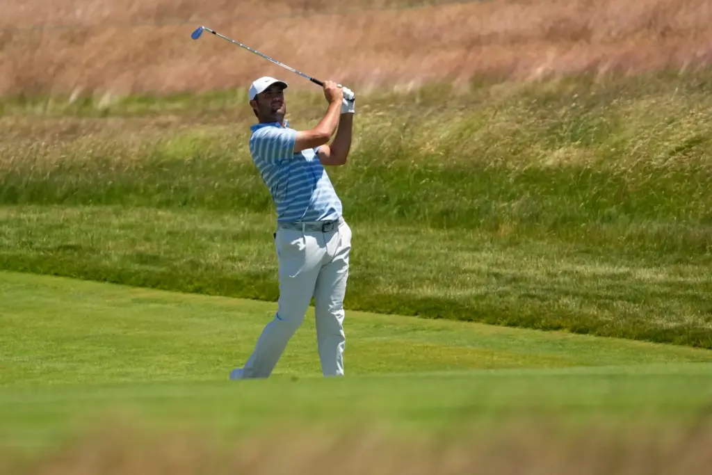 Scottie Scheffler watches his shot on the 13th hole during...