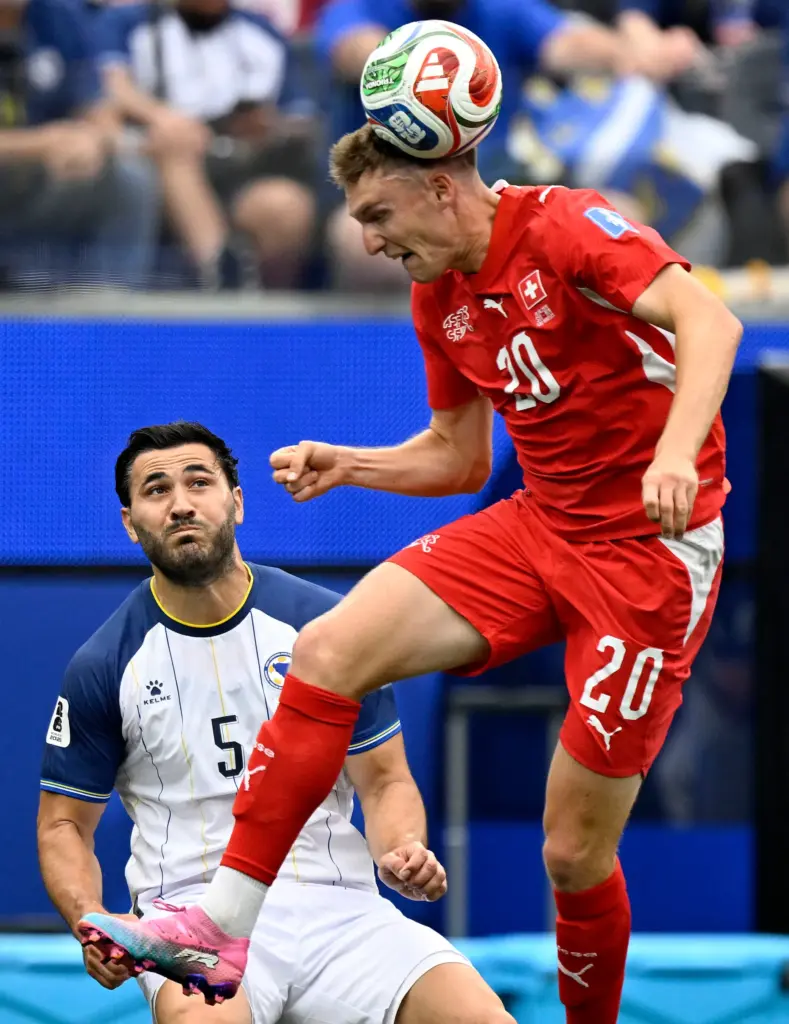 Switzerland midfielder Michel Aebischer (20) heads a ball away from...