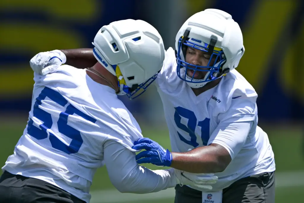 Rams defensive linemen Kobie Turner, right, and Braden Fiske go...