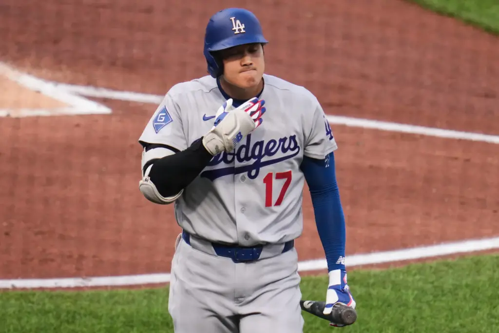Dodgers star Shohei Ohtani walks back to the bench after...