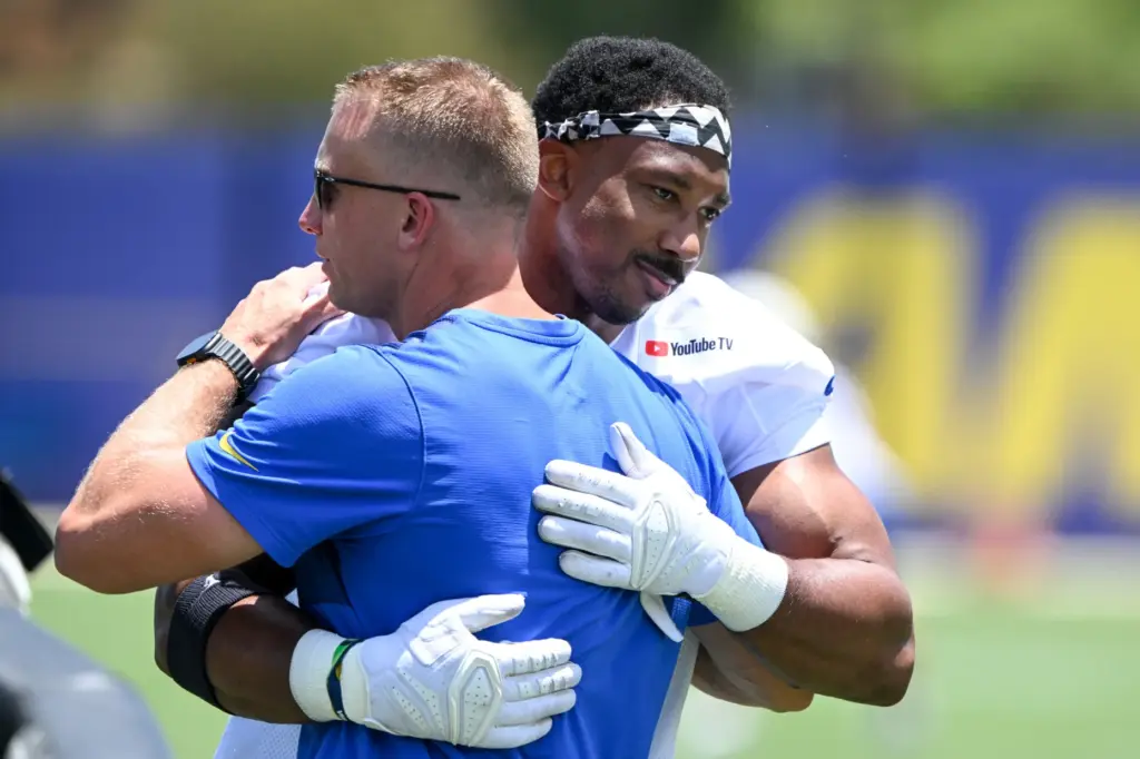 Newly acquired Rams defensive lineman Myles Garrett embraces an assistant...