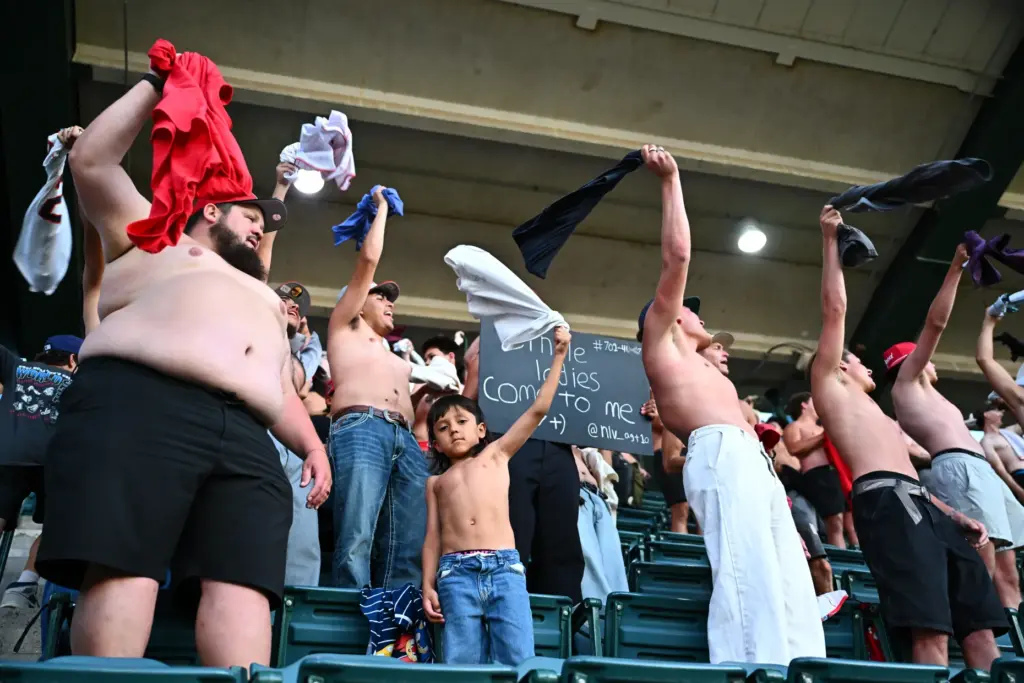 Shirtless fans cheer during the sixth inning of a game...