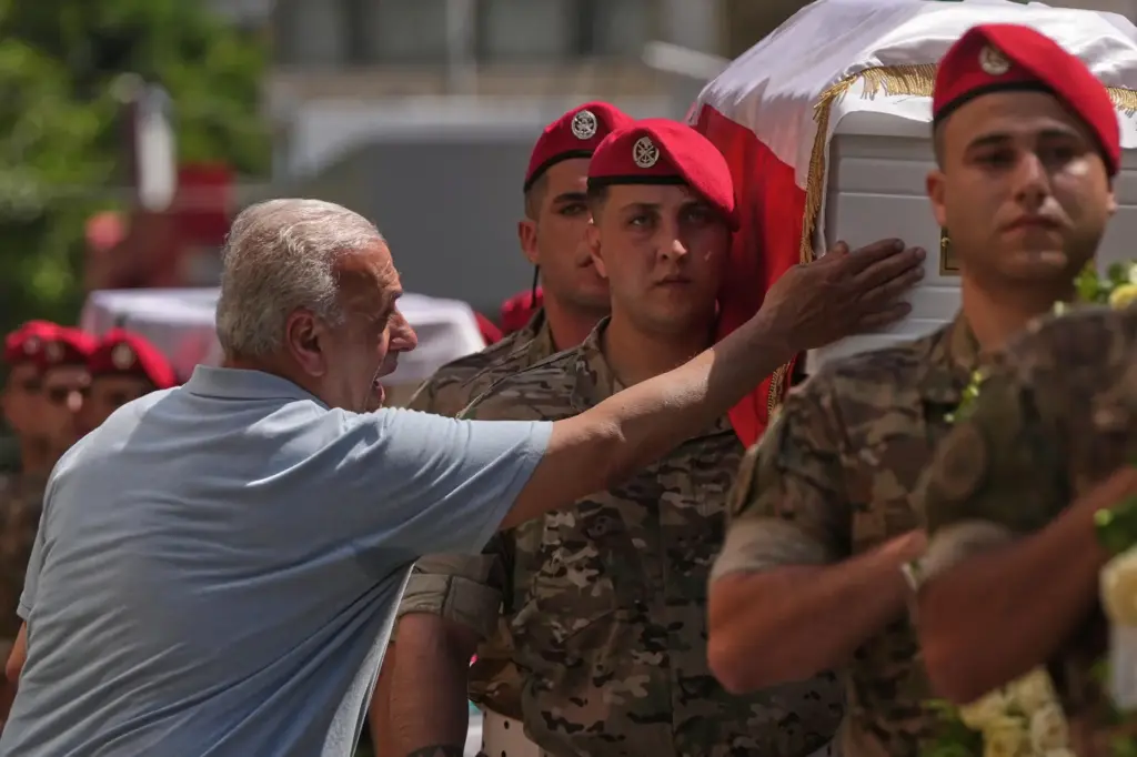 A mourner touches the coffin of the Lebanese army Brig....
