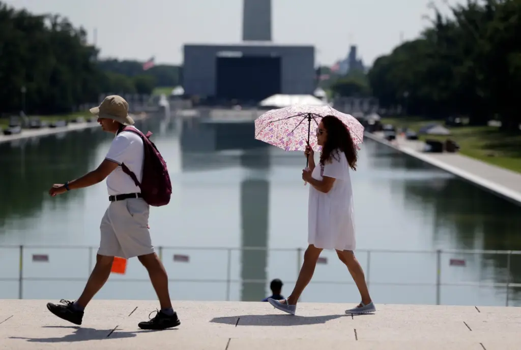 Visitors walk past the Lincoln Memorial Reflecting Pool, Tuesday, June...