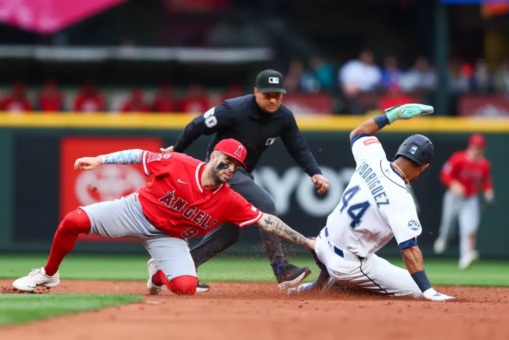 Angels shortstop Zach Neto, left, tags out the Seattle Mariners’...