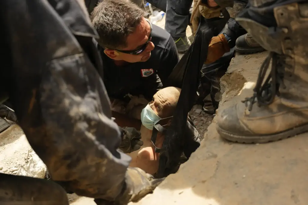 U.S. firefighters from the Fairfax County pull a survivor from...