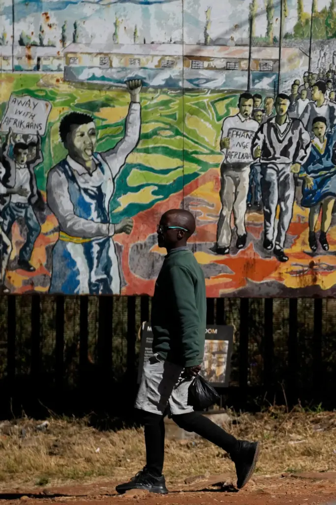 A man walks past a June 16 mural, in Soweto, South Africa.