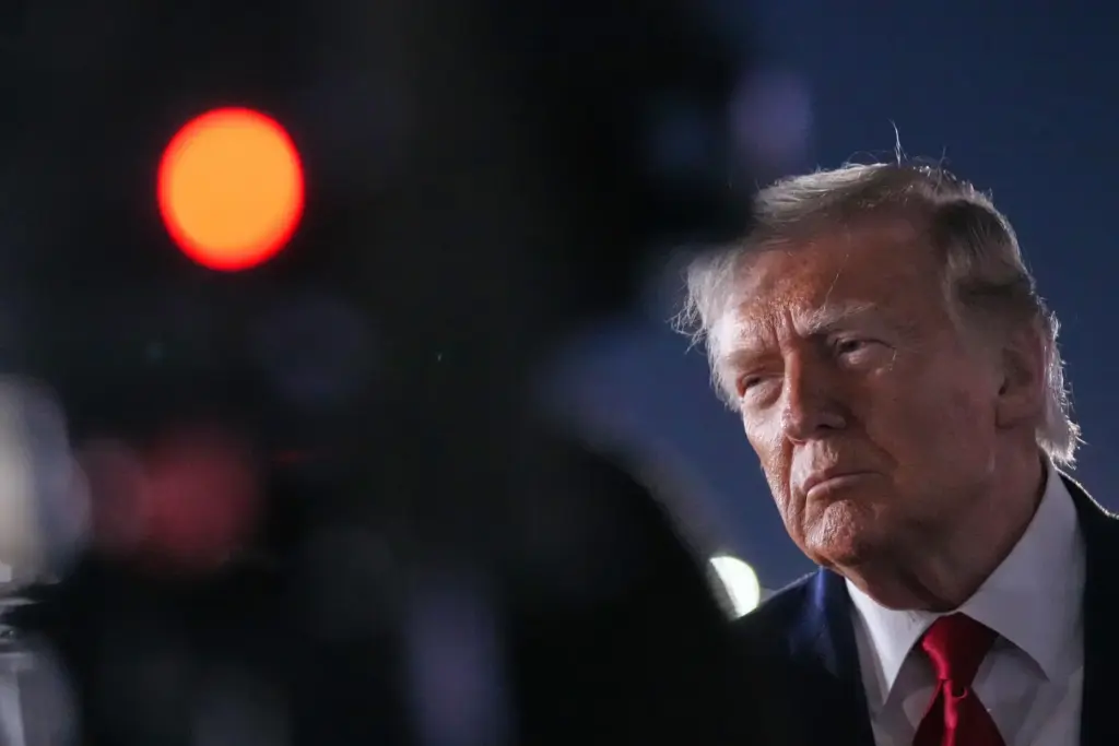 President Donald Trump talks with reporters before boarding Air Force One.