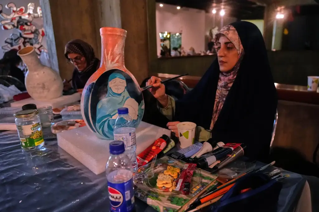 Artist Sahar Farhadravesh, works on a ceramic jar inspired by...