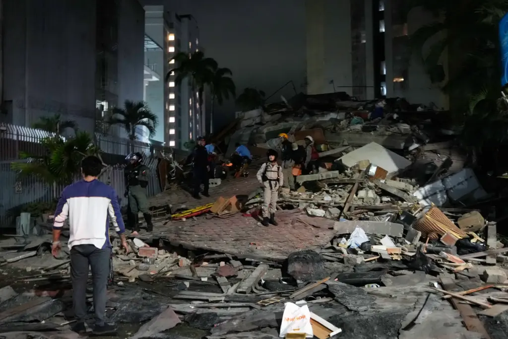 People walk amid debris after an earthquake in Caracas, Venezuela,...