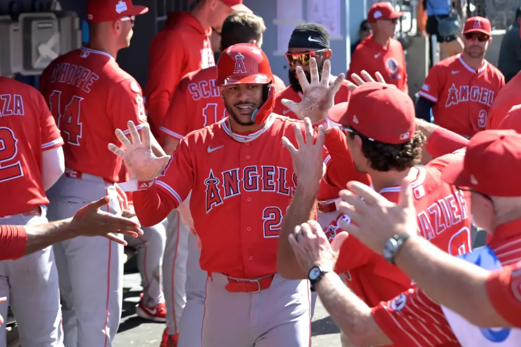 Angels’ Jose Siri, center, is greeted in the dugout after...