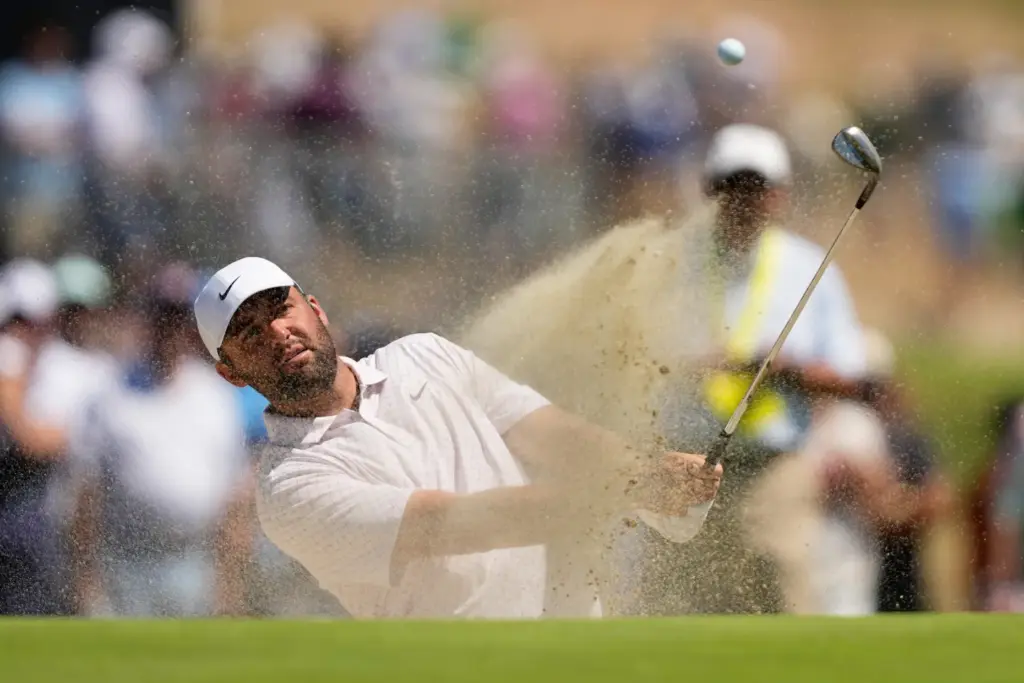 Scottie Scheffler hits from the bunker on the second hole...