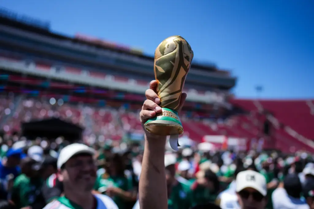 A fan holds up a replica of the World Cup...