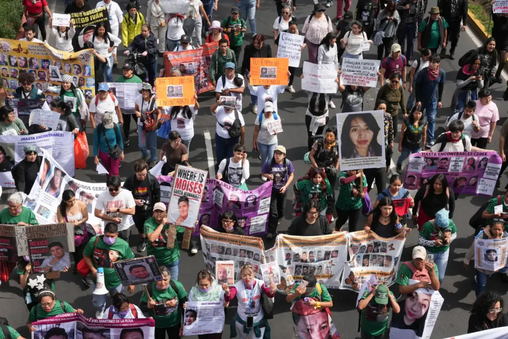 Relatives of Mexico’s disappeared march before the opening match of...