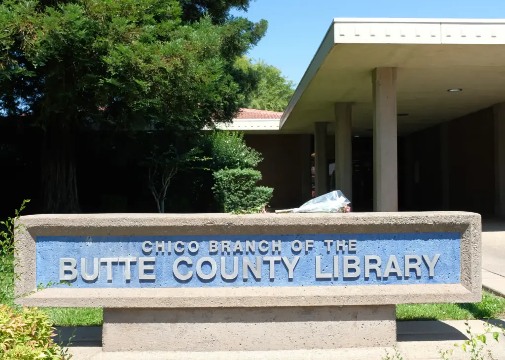 Flowers are laid on the Chico library’s sign Tuesday, June...