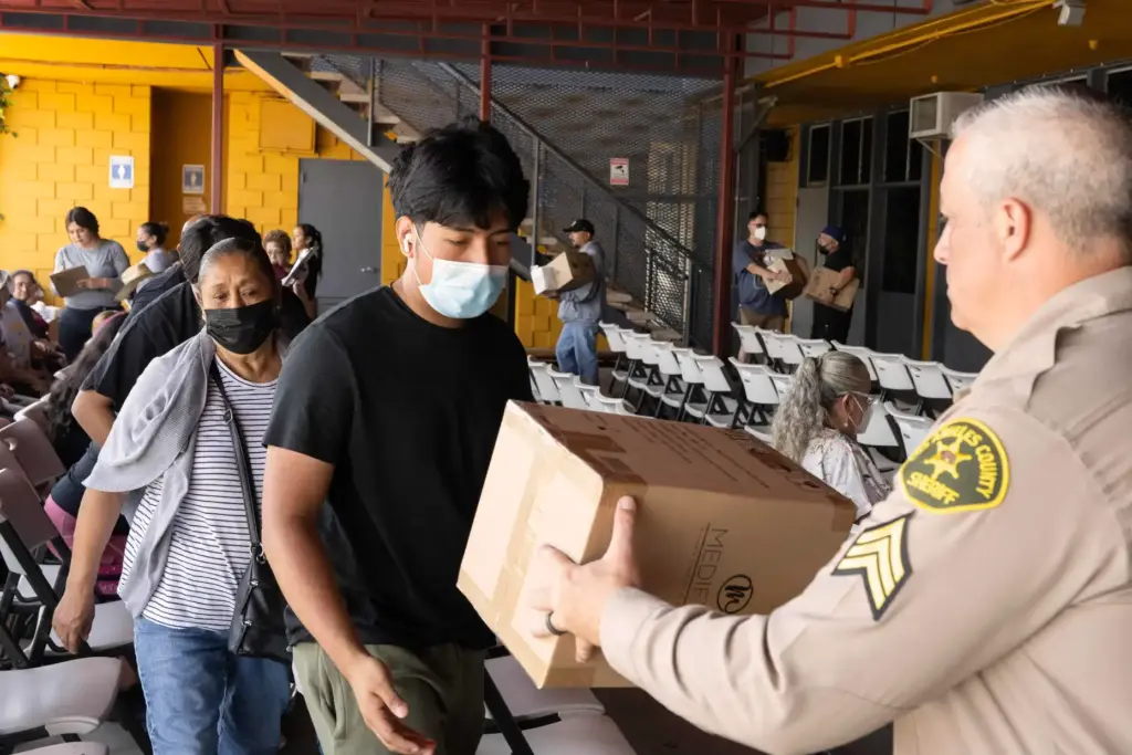 From right, Sgt. Shai Sheklow hands Rodrigo Flores and his...