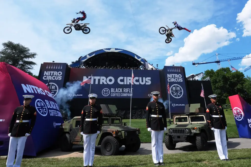 Motorsports athletes and stunt performers do a motorcycle jump ahead...