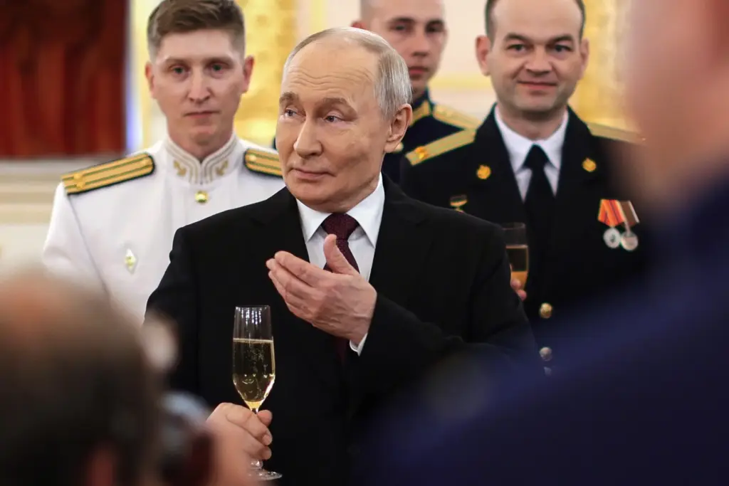 Russian President Vladimir Putin toasts with graduates of the country’s...
