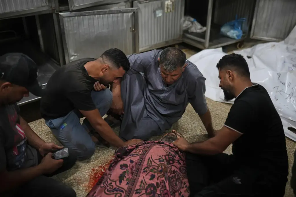 Relatives of Hani Abu Sweilem mourn beside his body at...