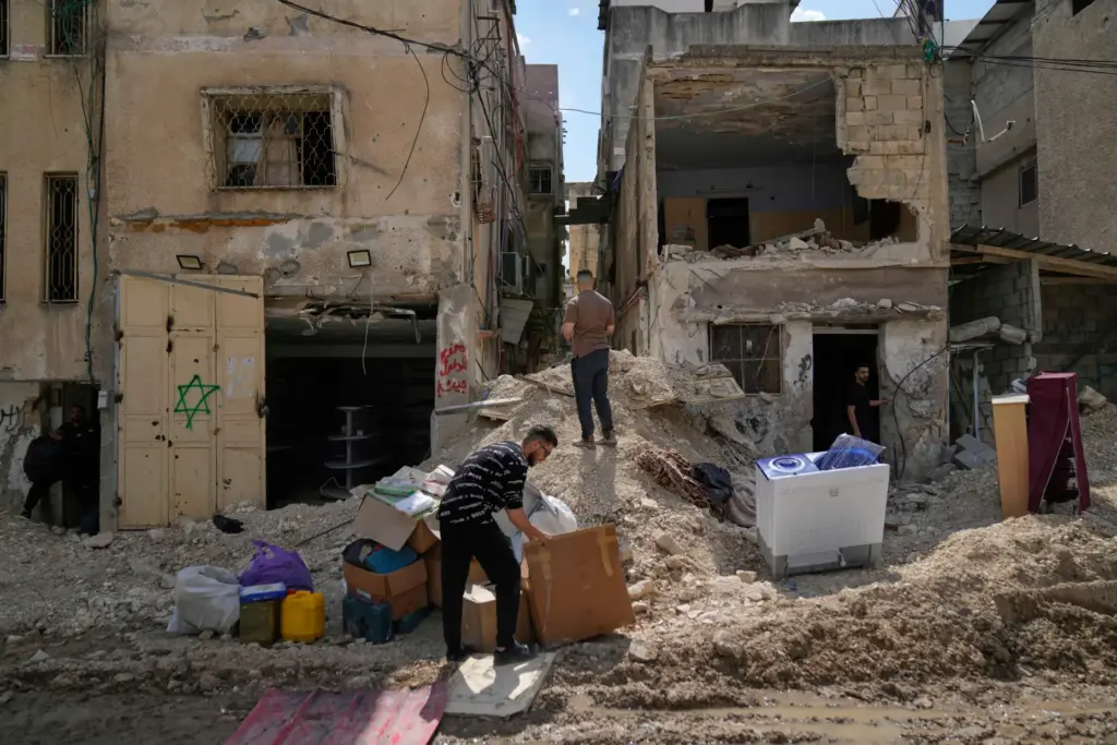 FILE – Residents of the now evacuated Palestinian refugee camp...