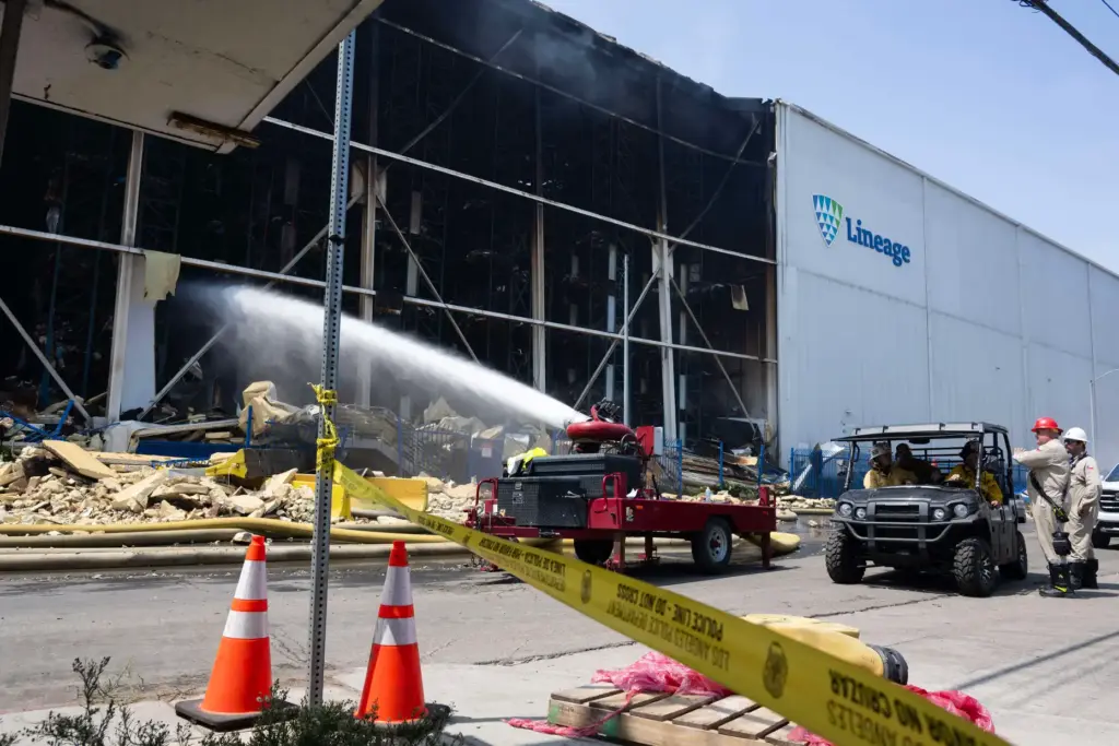 Firefighters and emergency crews continue to extinguish a massive fire...
