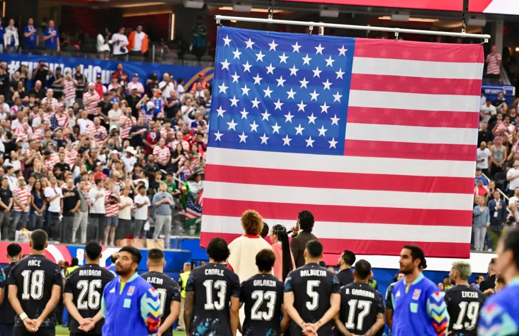 Fans and players look on during the national anthem before...