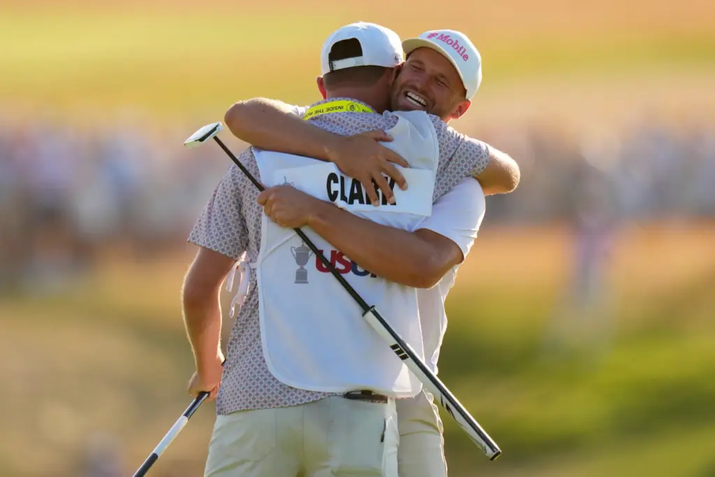 Wyndham Clark celebrates with his caddie David Pelekoudas after winning...