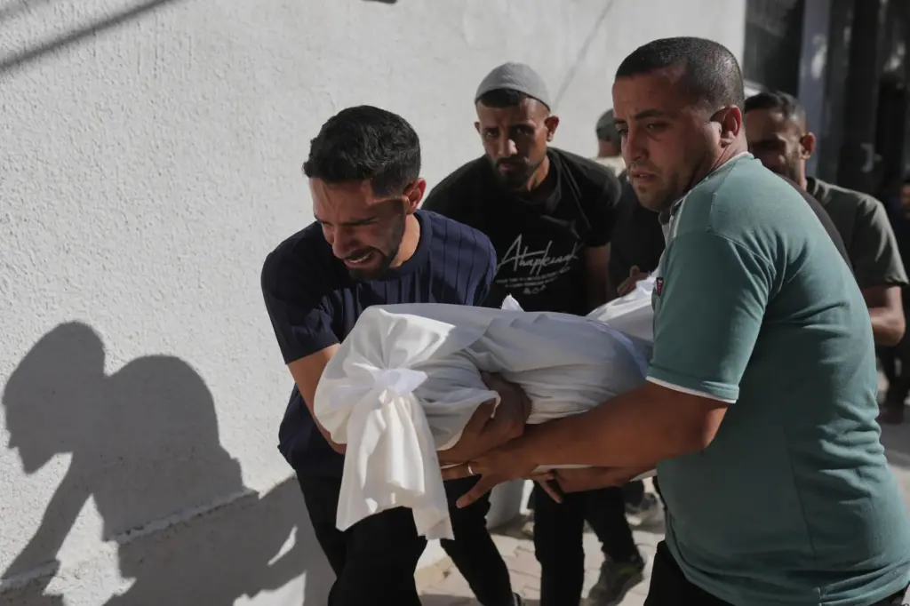 Relatives carry the body of Shadi Abu Sweilem, who was...