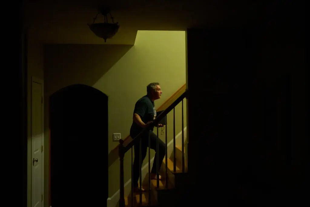 Chris Colocousis walks up the stairs in his home.
