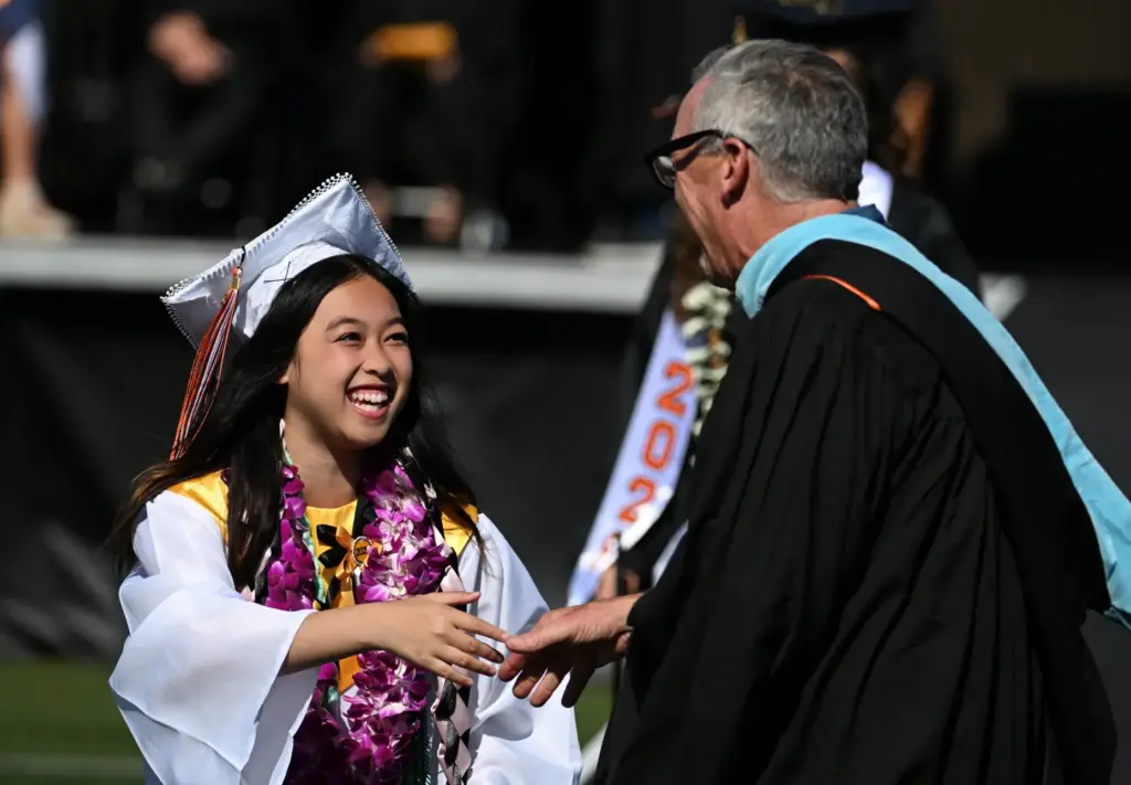 Graduates show your enthusiasm after receiving their diploma during the...