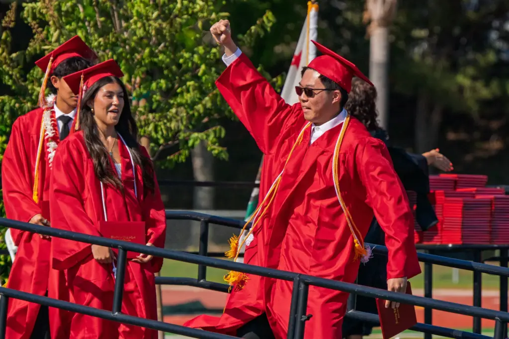 A Woodbridge High School senior raises his fist in celebration...