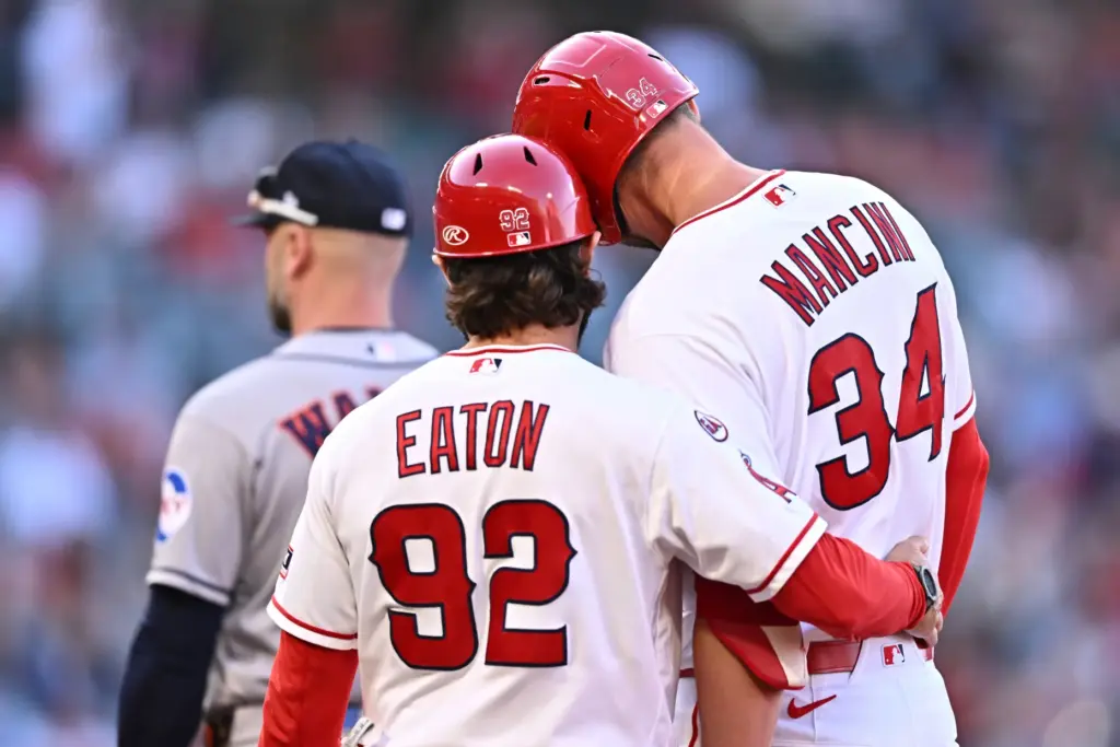The Angels’ Trey Mancini, right, is greeted by first base...