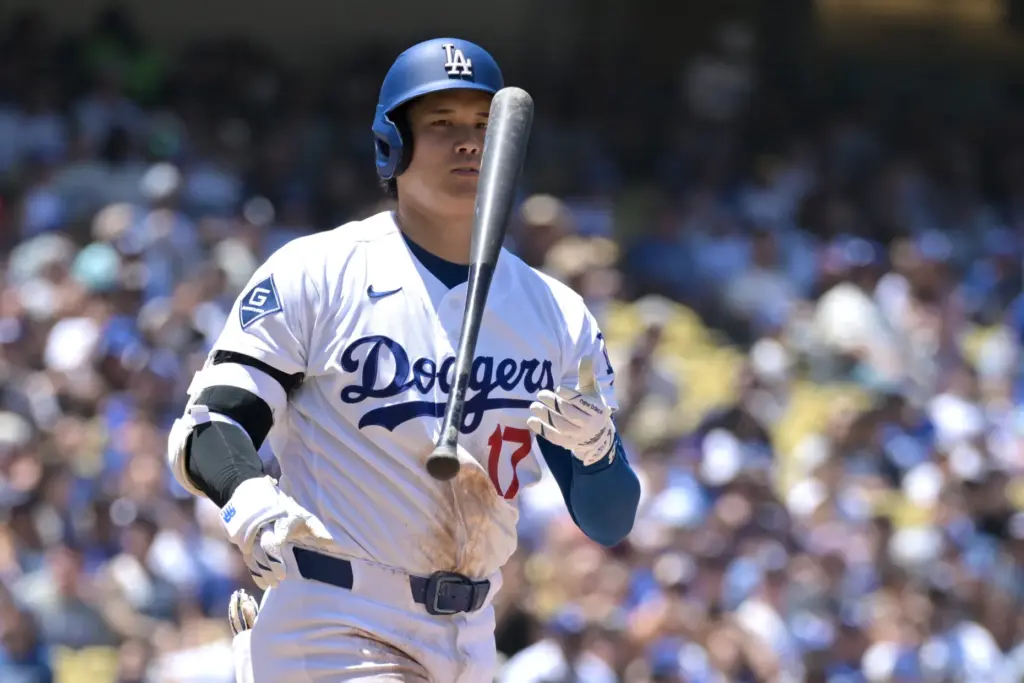 Dodgers’ Shohei Ohtani flips his bat after a swing and...